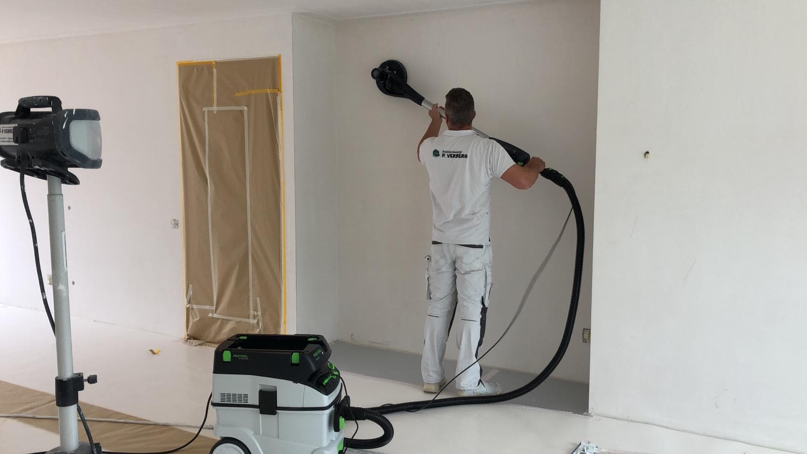 Schilder van P. Verberg schuurt de wanden voor dat hier Renovlies op komt
