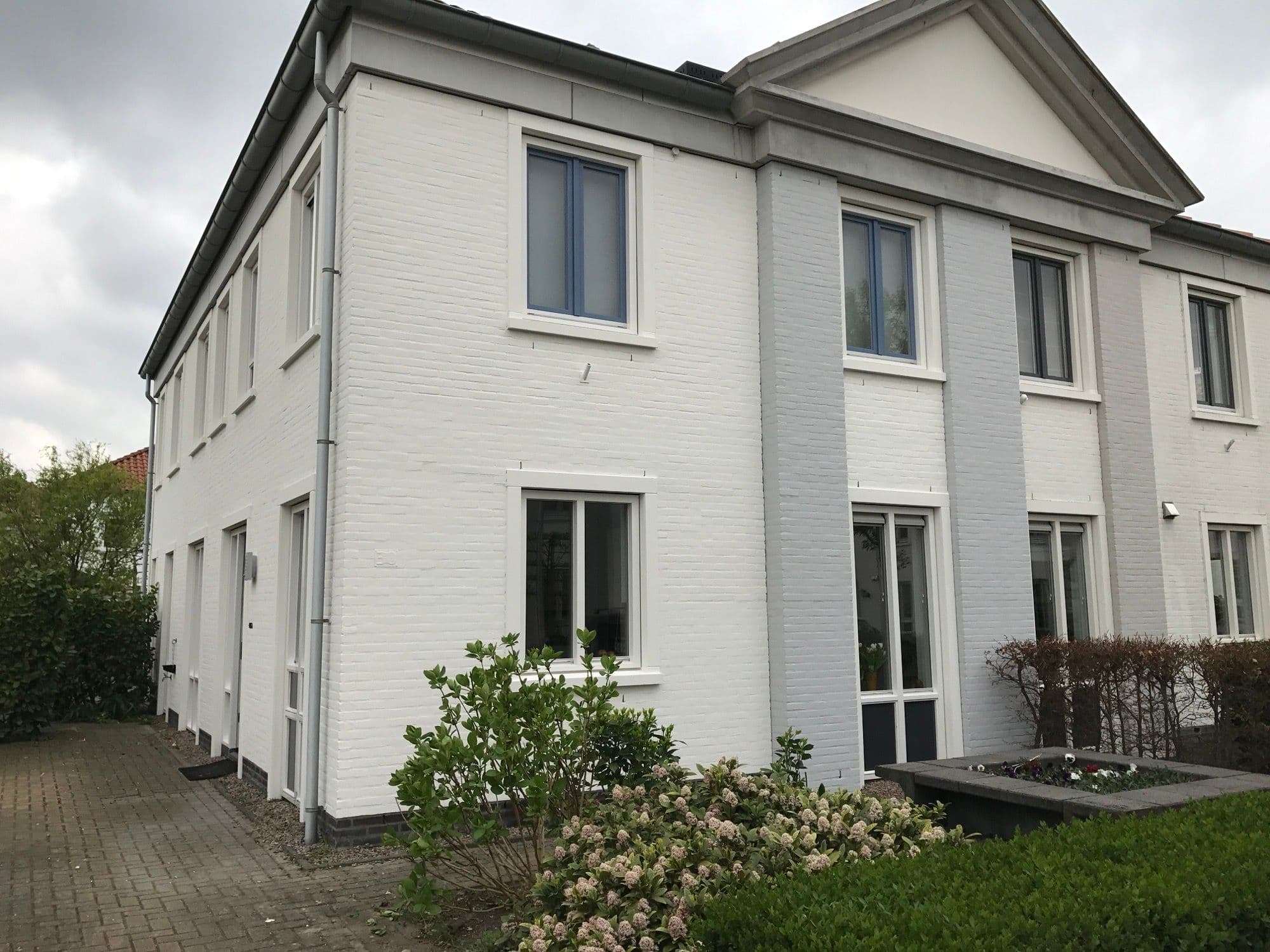 Klassieke witte gevel van een woning in Bodegraven, geschilderd door P. Verberg
