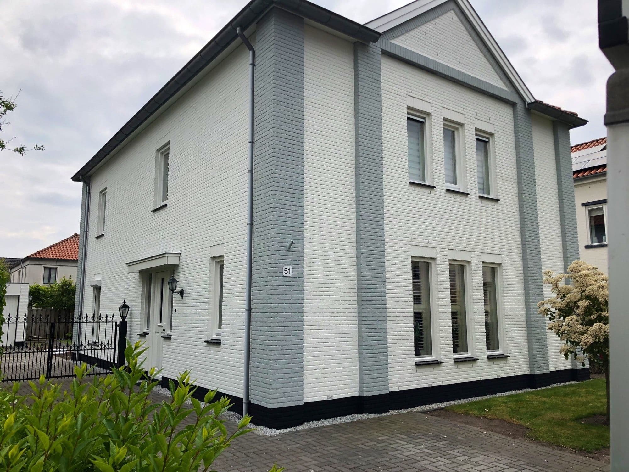 Wit gestucte woning met grijze accenten in Boskoop, geschilderd door P. Verberg